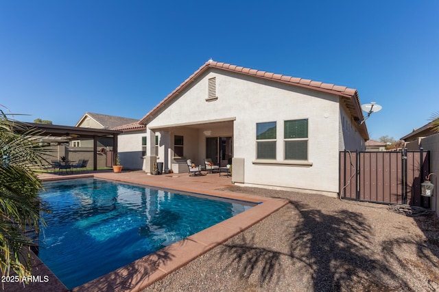 back of house with a fenced in pool and a patio