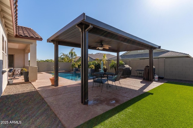 view of patio with ceiling fan, a fenced in pool, and area for grilling
