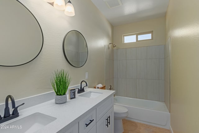 full bathroom featuring tile patterned flooring, toilet, tiled shower / bath combo, and vanity