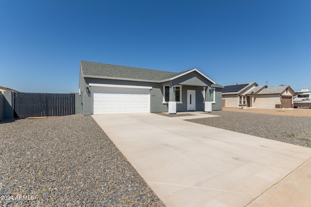 view of front of house with a garage, driveway, fence, and stucco siding