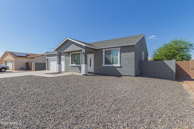 view of front of house with roof with shingles, stucco siding, an attached garage, fence, and driveway