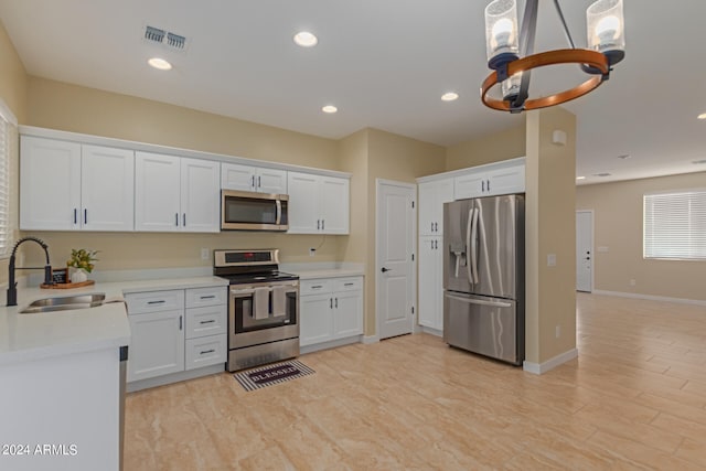 kitchen with white cabinets, an inviting chandelier, stainless steel appliances, and sink