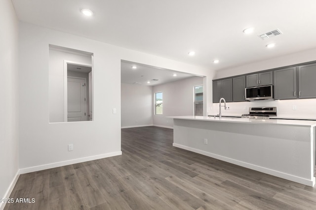 kitchen with sink, dark hardwood / wood-style flooring, gray cabinets, and appliances with stainless steel finishes