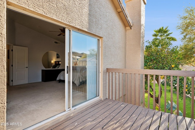 wooden terrace with a ceiling fan and visible vents