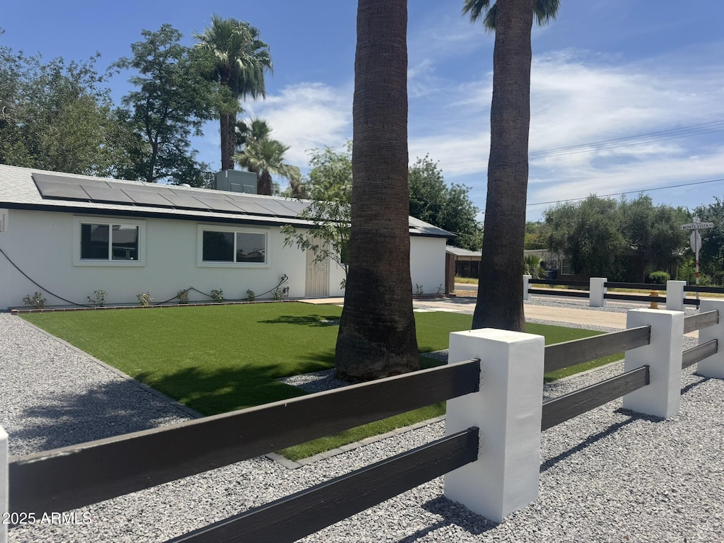 2201 N 29th Pl, Phoenix, AZ 85008 - view of front of home with a fenced front yard, solar panels, and stucco siding