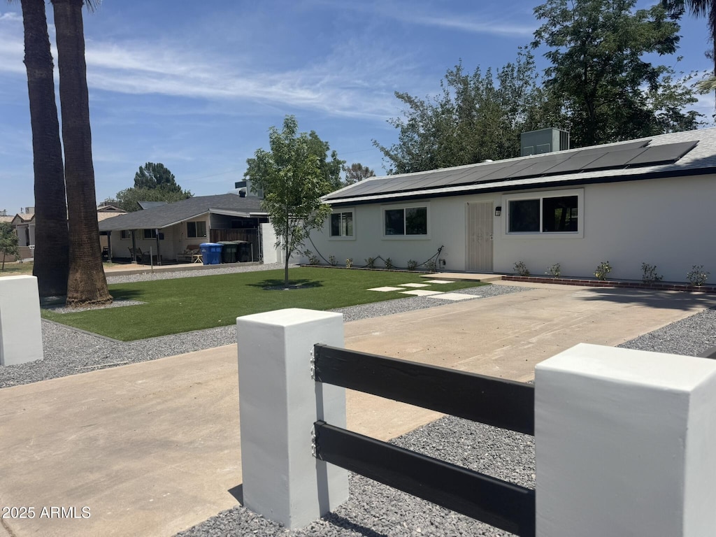 2201 N 29th Pl, Phoenix, AZ 85008 - ranch-style house with solar panels, a fenced front yard, and stucco siding
