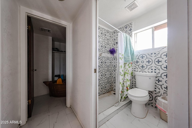 5239 W Maryland Ave, Glendale, AZ 85301 - bathroom featuring marble look tile flooring, a stall shower, and toilet