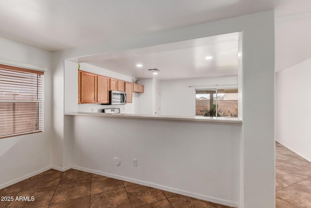 12425 W Willow Ave, El Mirage, AZ 85335 - kitchen featuring stainless steel microwave, tile patterned floors, a peninsula, light countertops, and recessed lighting