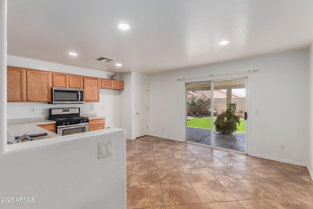 12425 W Willow Ave, El Mirage, AZ 85335 - kitchen featuring appliances with stainless steel finishes, recessed lighting, light countertops, baseboards, and brown cabinets