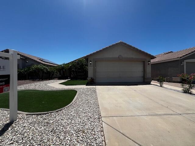 12425 W Willow Ave, El Mirage, AZ 85335 - view of front of house with an attached garage, concrete driveway, and stucco siding