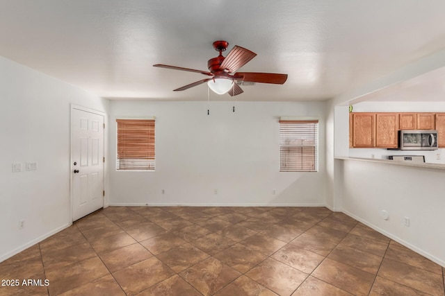 12425 W Willow Ave, El Mirage, AZ 85335 - unfurnished living room featuring a ceiling fan, baseboards, and tile patterned flooring