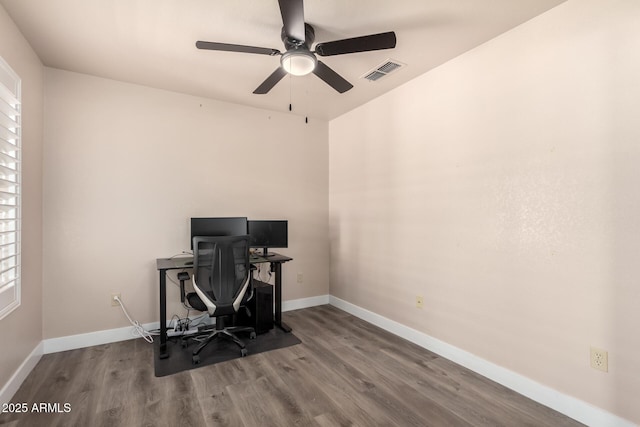 home office featuring baseboards, ceiling fan, visible vents, and wood finished floors