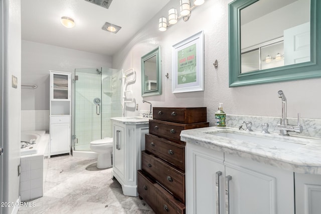 bathroom featuring visible vents, a bath, two vanities, a sink, and a stall shower