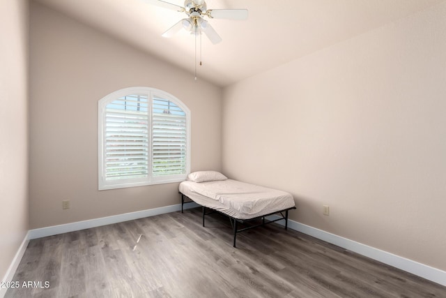 bedroom featuring baseboards, a ceiling fan, lofted ceiling, and wood finished floors