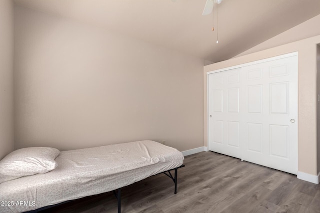 bedroom with a ceiling fan, baseboards, vaulted ceiling, and wood finished floors