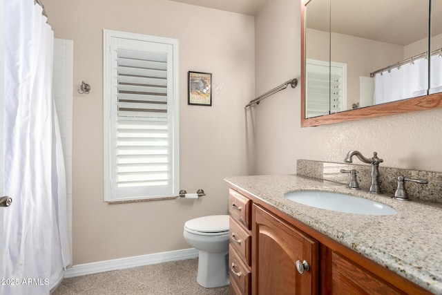 bathroom with baseboards, vanity, toilet, and curtained shower