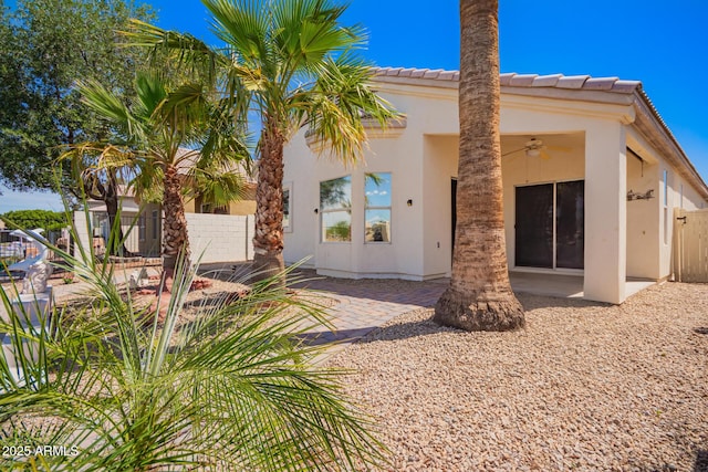 back of house featuring fence, a ceiling fan, stucco siding, and a patio area