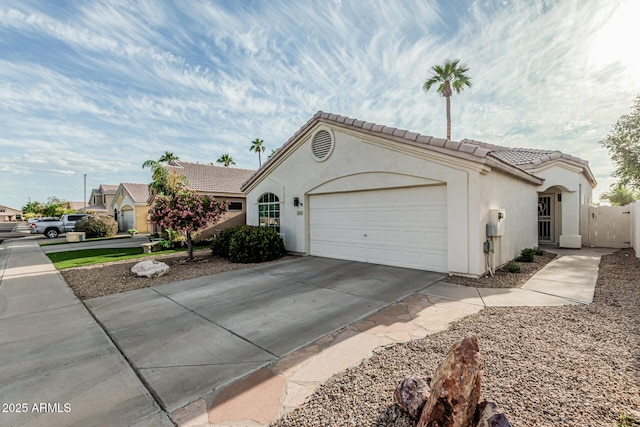 14624 N 90th Ln, Peoria, AZ 85381 - view of front of house featuring fence, an attached garage, a tile roof, concrete driveway, and stucco siding