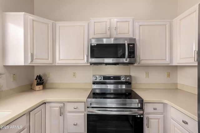 kitchen featuring light countertops, white cabinets, and appliances with stainless steel finishes