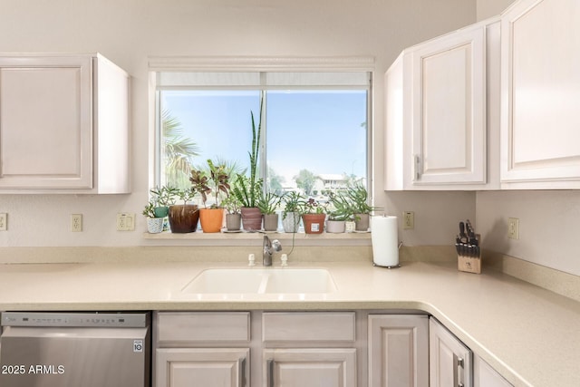 kitchen with a sink, light countertops, white cabinets, and dishwasher