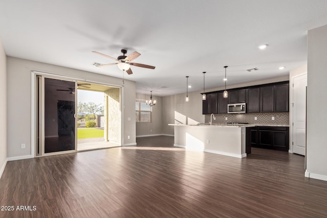 18360 W Alice Ave, Waddell, AZ 85355 - unfurnished living room with a sink, dark wood-style floors, baseboards, ceiling fan with notable chandelier, and recessed lighting
