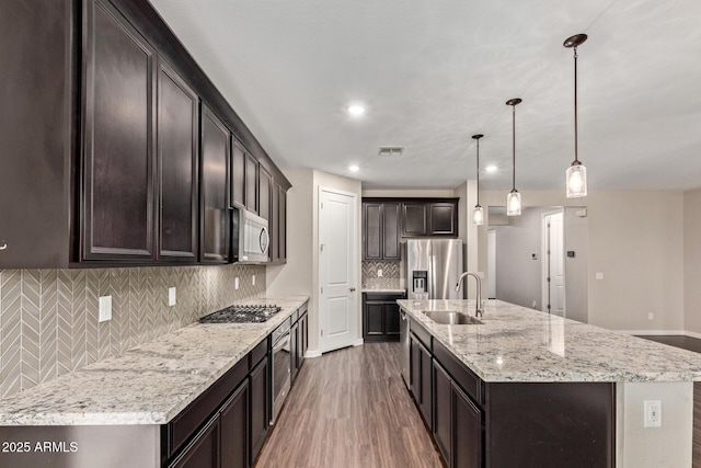 18360 W Alice Ave, Waddell, AZ 85355 - kitchen featuring visible vents, appliances with stainless steel finishes, dark brown cabinetry, a sink, and light wood-style floors