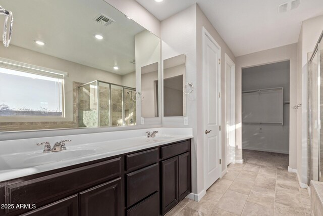 18360 W Alice Ave, Waddell, AZ 85355 - full bathroom with a sink, visible vents, a spacious closet, and a shower stall