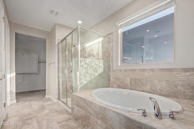 18360 W Alice Ave, Waddell, AZ 85355 - bathroom with a stall shower, visible vents, a walk in closet, and a bath
