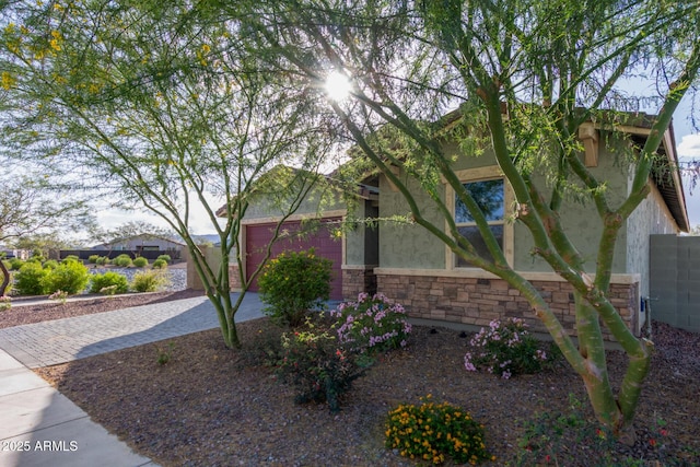 18360 W Alice Ave, Waddell, AZ 85355 - view of front facade with stone siding, a garage, driveway, and stucco siding