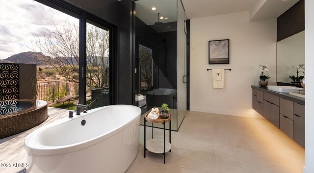 full bath featuring a mountain view, a stall shower, vanity, a freestanding bath, and tile patterned flooring
