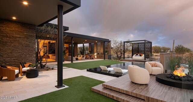 view of patio / terrace with an outdoor kitchen and an outdoor living space with a fire pit