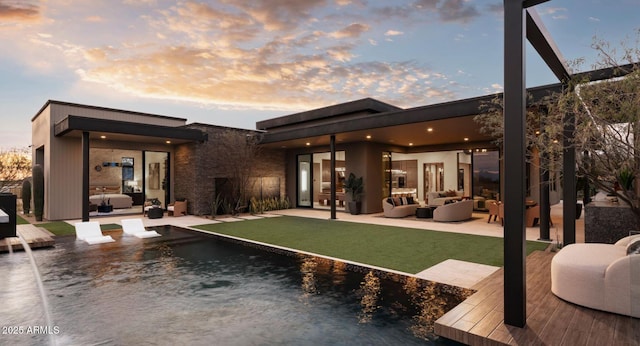 rear view of property featuring an outdoor hangout area, a patio area, and a yard