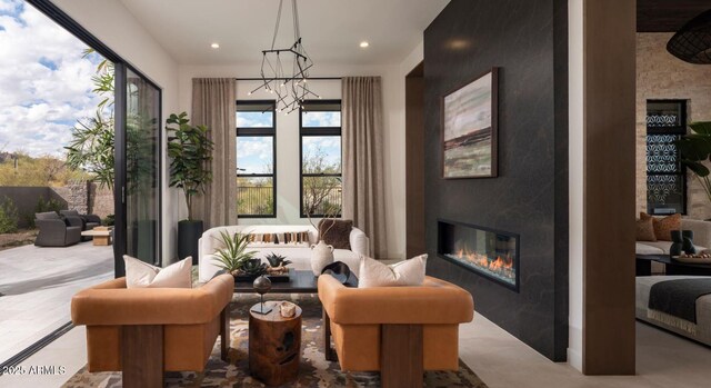 living area with a glass covered fireplace, recessed lighting, and a chandelier