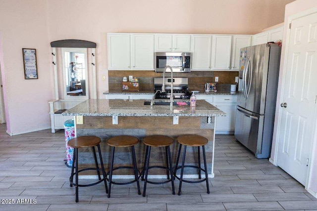 kitchen featuring stainless steel appliances, light wood-type flooring, and white cabinets