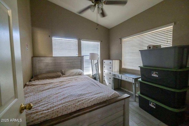 bedroom with vaulted ceiling, multiple windows, light wood-style floors, and ceiling fan