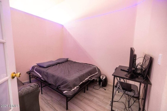 bedroom featuring light wood-type flooring and vaulted ceiling