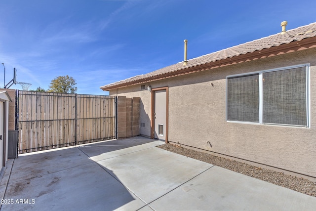 view of patio featuring fence and a gate