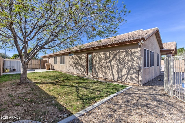 view of property exterior with a patio, stucco siding, and a tiled roof