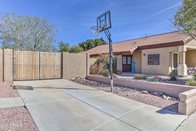 view of basketball court featuring a gate and fence