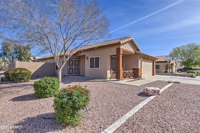 view of front of property featuring a garage, stucco siding, fence, concrete driveway, and a tiled roof