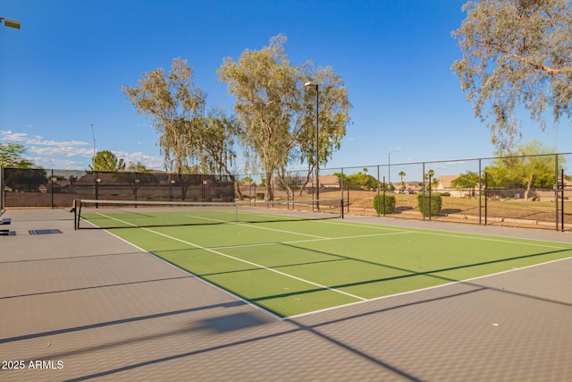 view of tennis court with community basketball court and fence
