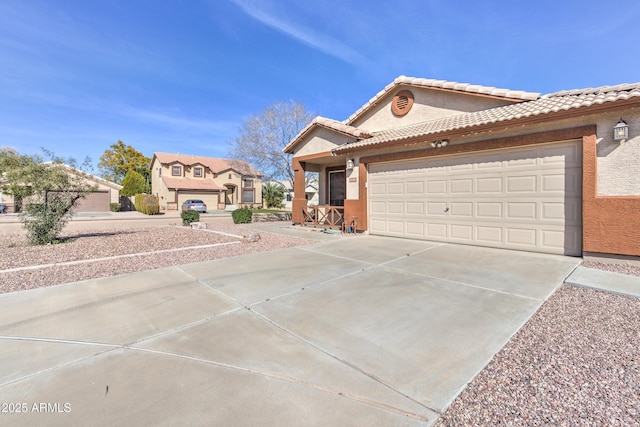 view of front of home with driveway, a garage, stucco siding, and a tiled roof