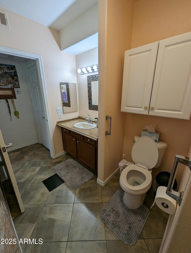 bathroom with toilet, tile patterned floors, and vanity