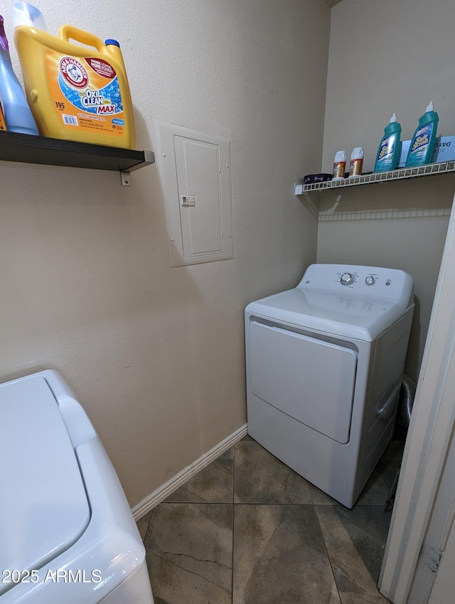 laundry room featuring washing machine and dryer, electric panel, and dark tile patterned floors