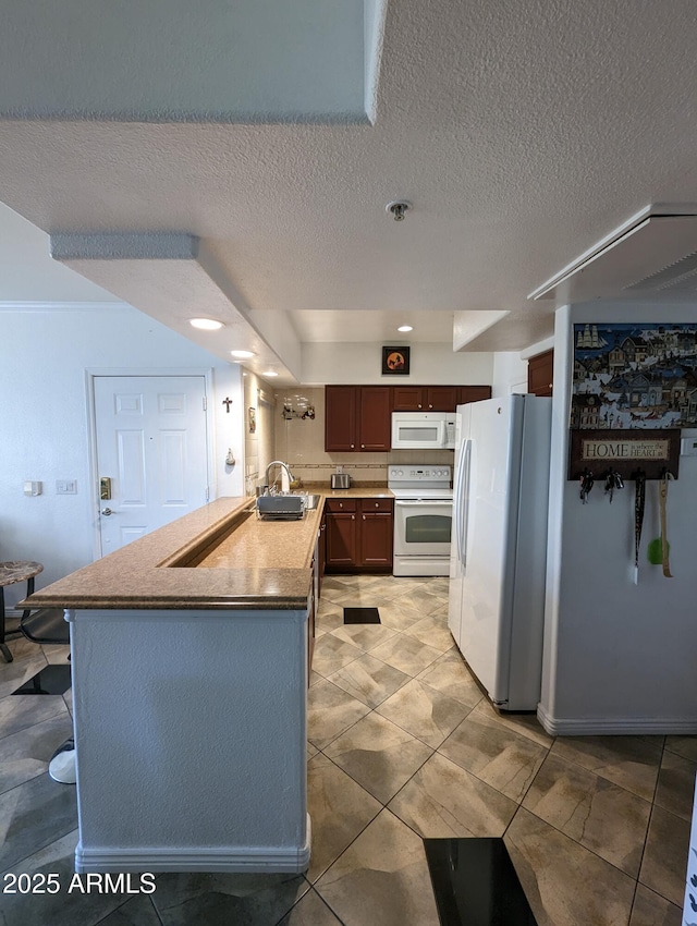 kitchen featuring a textured ceiling, sink, and white appliances