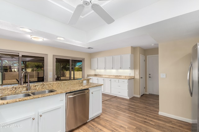 kitchen featuring stainless steel appliances, white cabinetry, sink, light stone countertops, and light hardwood / wood-style flooring