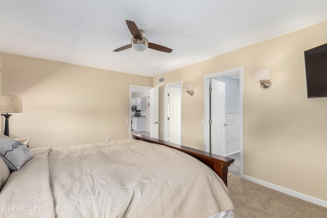 carpeted bedroom with ceiling fan and ensuite bath