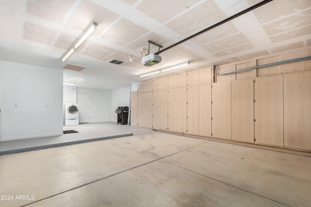 garage with a garage door opener and washer / clothes dryer