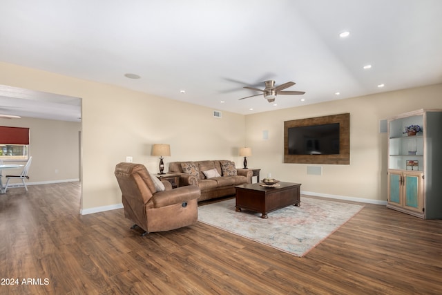 living room featuring ceiling fan and dark hardwood / wood-style floors