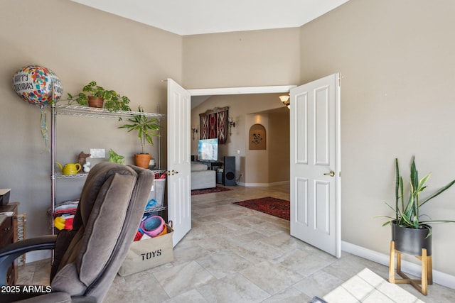 office area with baseboards and arched walkways